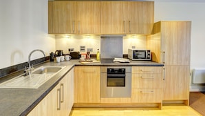 Una cucina moderna con mobili in legno, elettrodomestici in acciaio inossidabile e un piano di lavoro in granito.