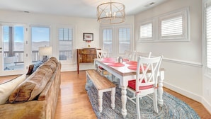 A spacious dining area with a wooden table and chairs, a bench, and a chandelier. - Wintergreens R322- Mtn Condo/View, Gated Resort, Indoor/Outdoor Pools & Hot Tub (Banner Elk)