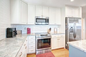 Lavavajillas, cafetera y tetera, utensilios de cocina y comedor