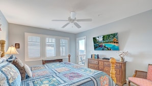 A bedroom with a large bed, a ceiling fan, a dresser, a chair, and a TV on the wall. - Wintergreens R322- Mtn Condo/View, Gated Resort, Indoor/Outdoor Pools & Hot Tub (Banner Elk)