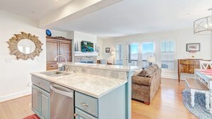A spacious living area with a kitchen island, a dining table, and a sofa. - Wintergreens R322- Mtn Condo/View, Gated Resort, Indoor/Outdoor Pools & Hot Tub (Banner Elk)