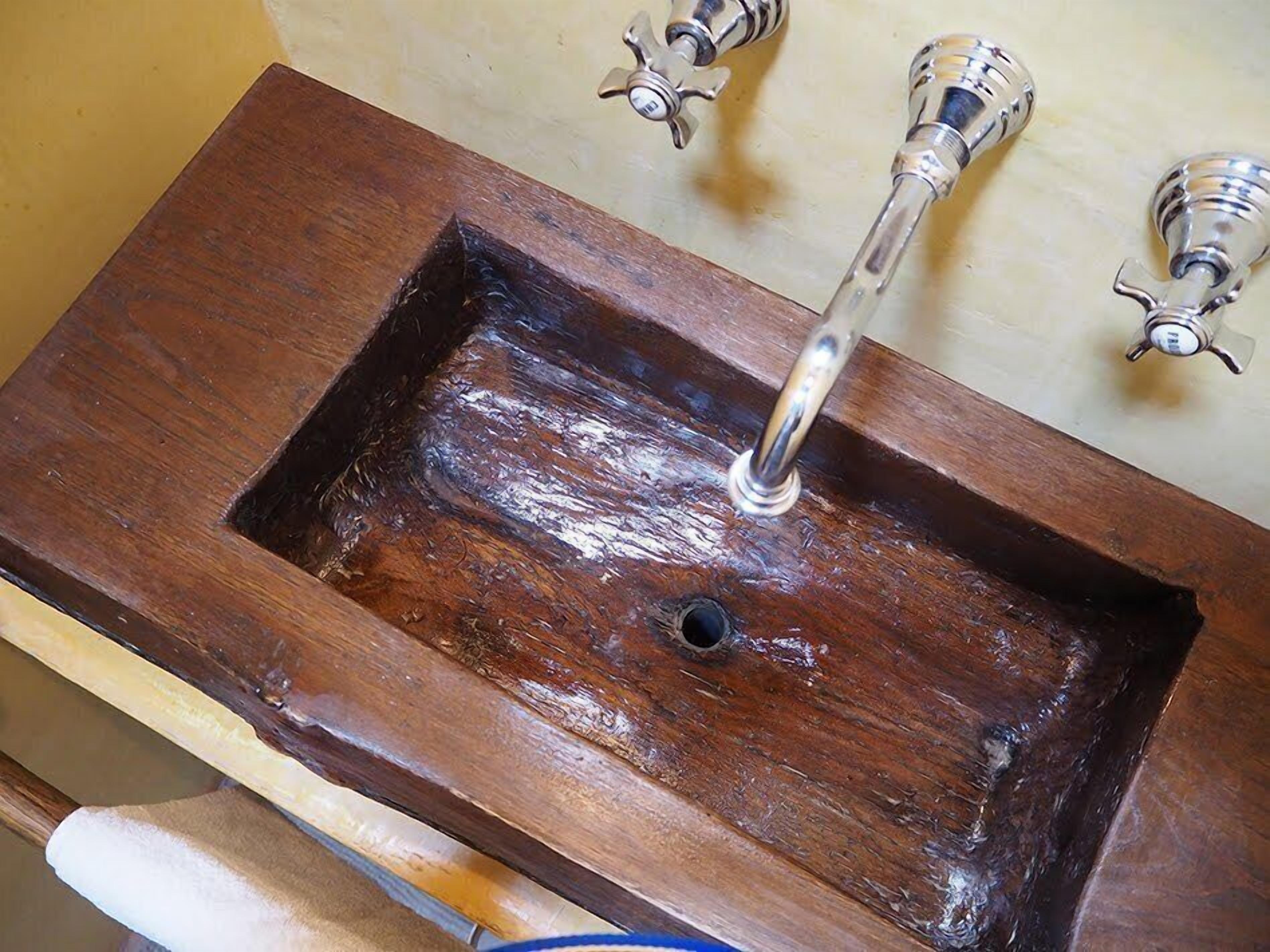 A wooden sink with a single faucet.