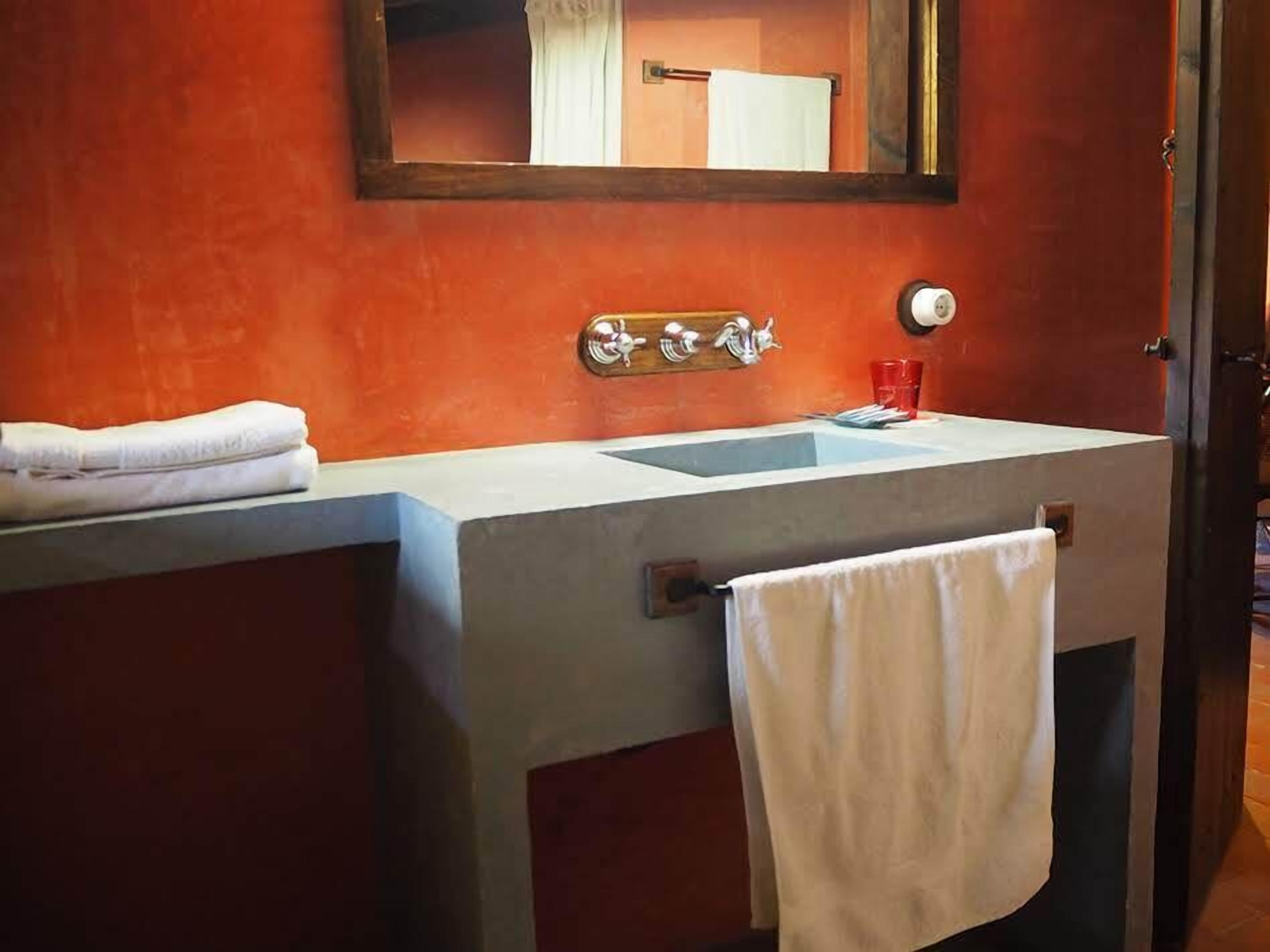 A bathroom with a white sink, a mirror, and a towel rack.
