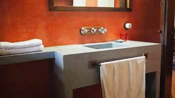 A bathroom with a white sink, a mirror, and a towel rack.