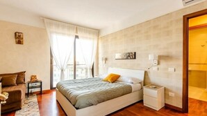 A bedroom with a bed, bedside table, and a window with curtains. - The House of the Pine Nativity (Napoli)