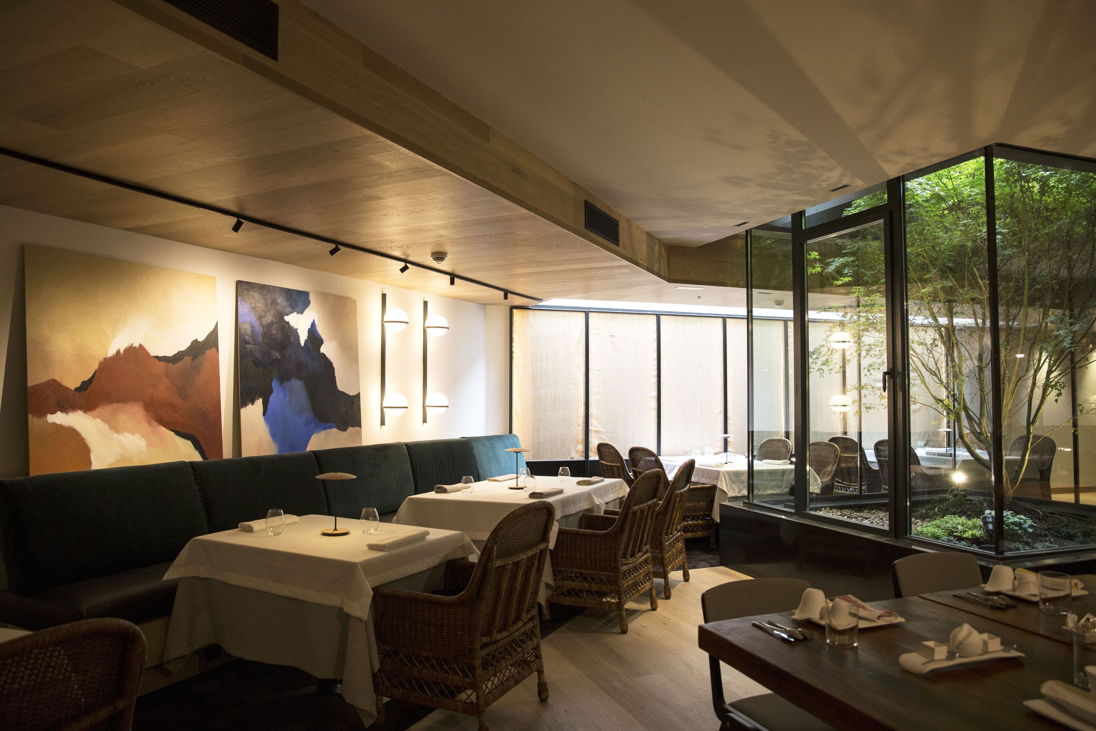 Ein Restaurant mit Tischen, Stühlen und Kunstwerken an den Wänden.