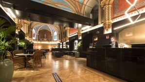 A hotel lobby with a reception desk, seating area, and decorative elements. - Hotel Zenit Convento San Martín (San Sebastián)
