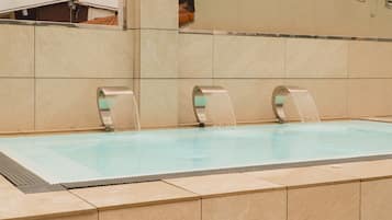 Una piscina con tres chorros de agua.