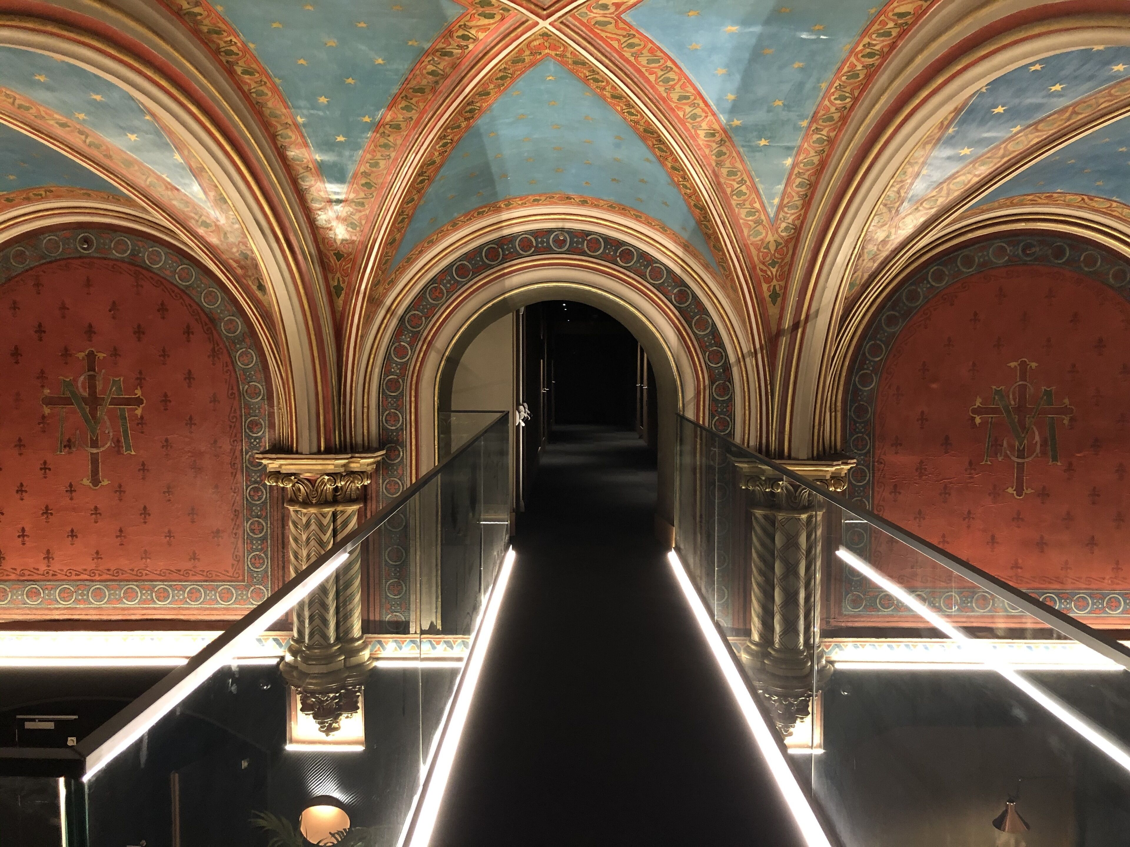 A grand staircase with ornate arches and a dark interior.