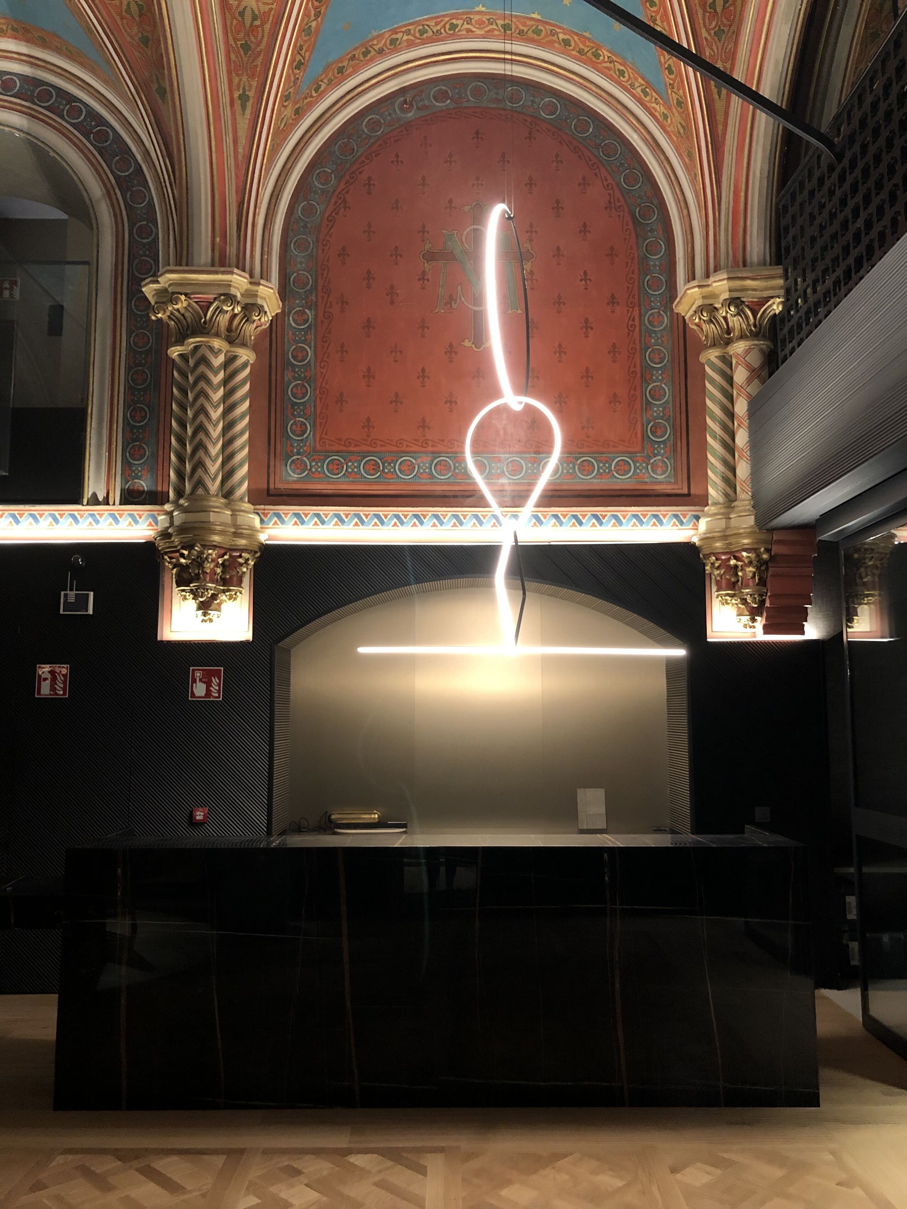 Un interior imponente con columnas ornamentadas, un gran techo abovedado e iluminación moderna.