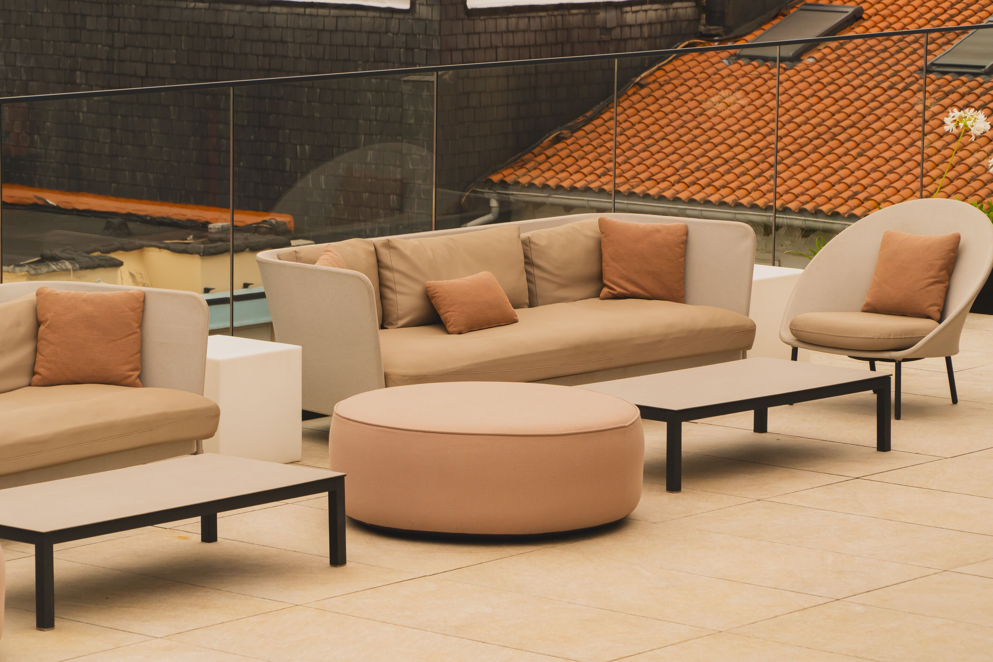 Un área de estar moderna con sofá, sillones y reposapiés.