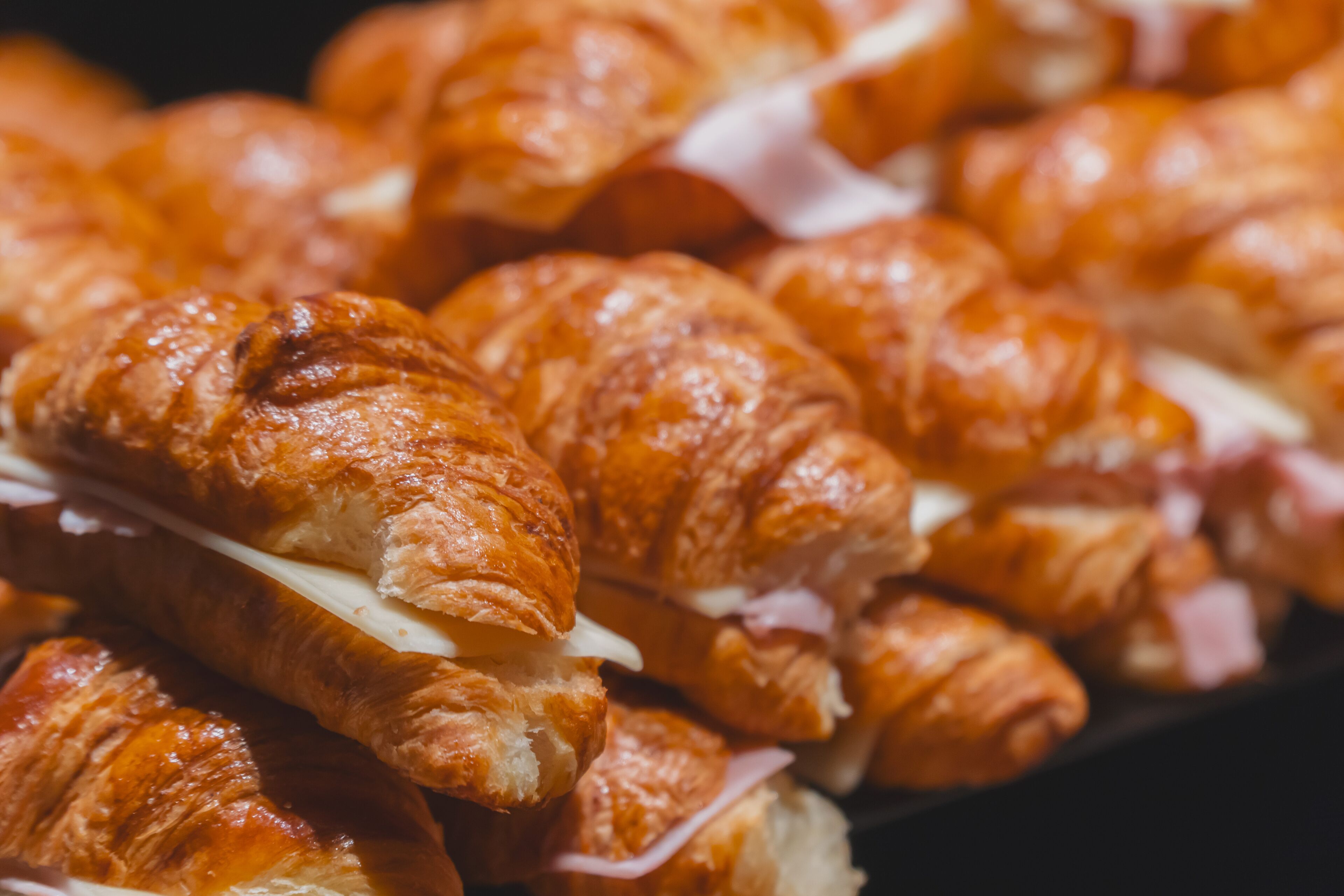 A close-up of golden-brown croissants with visible fillings.