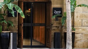 The entrance of the Zenit Hotels with a wooden door, a signboard, and potted plants. - Hotel Zenit Convento San Martín (San Sebastián)