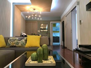 Departamento urbano, 1 cama Queen size y sofá cama, para no fumadores, vista a la ciudad | Área de sala de estar | Televisión LCD de 42 pulgadas con canales por cable y televisión