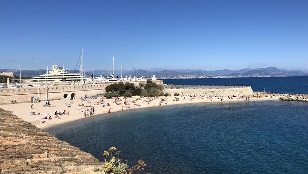 A coastal beach with a marina, rocky shoreline, and clear blue sky. - Ferme le Pavillon (Bargemon)