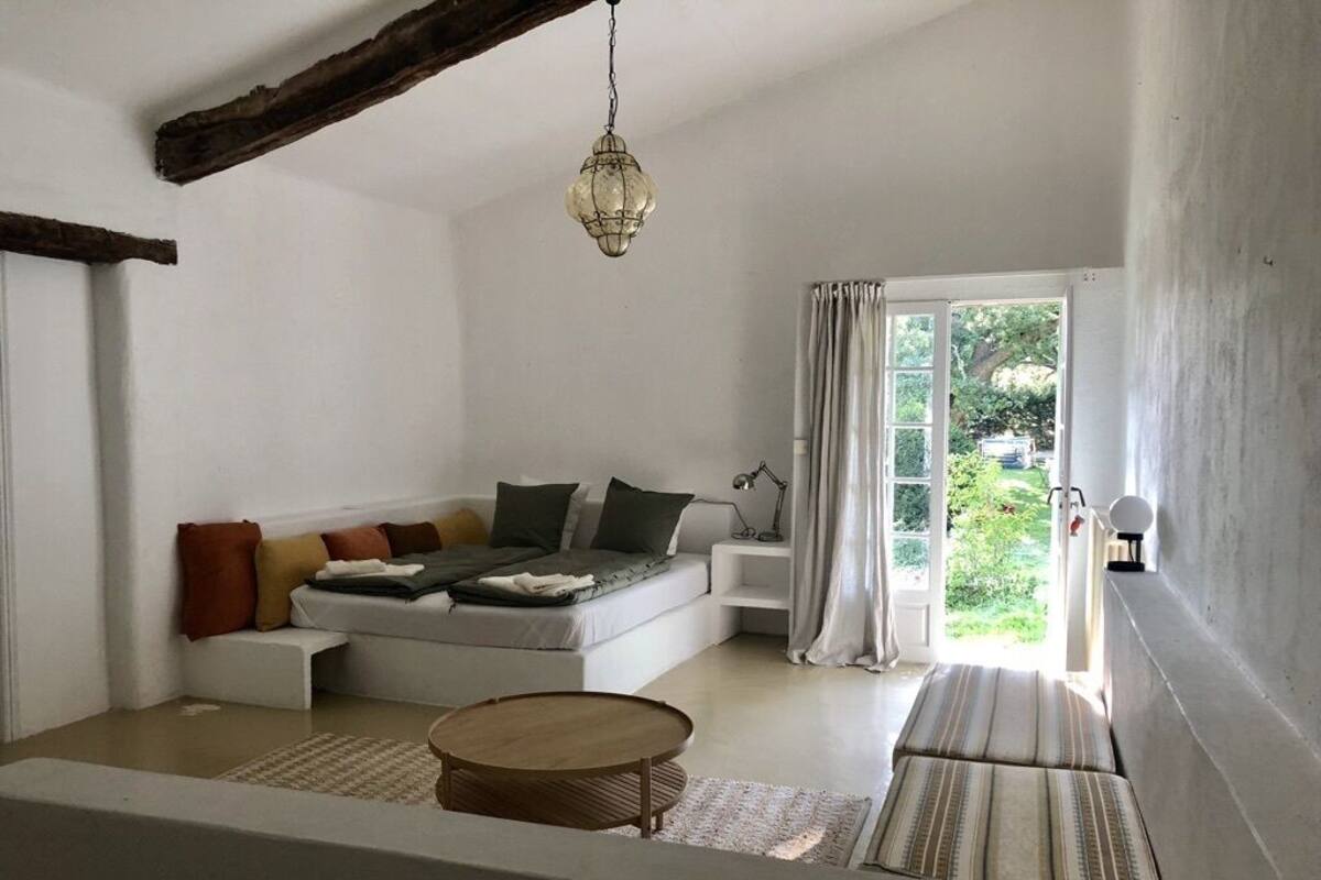 A modern living room with a sectional sofa, a round coffee table, and a view of the outdoors through a large window.