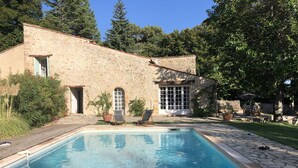A stone building with a swimming pool, two lounge chairs, and a patio area. - Ferme le Pavillon (Bargemon)