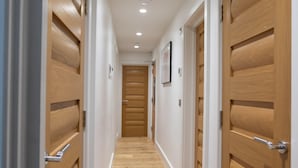 Un pasillo con puertas y piso de madera.