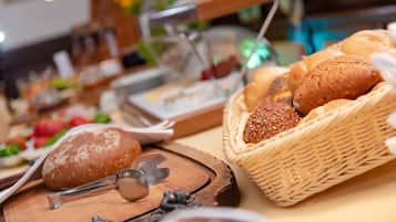 A buffet setup with various breads and pastries.