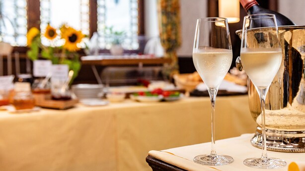 Een tafel met twee champagneglazen en een champagnefles.
