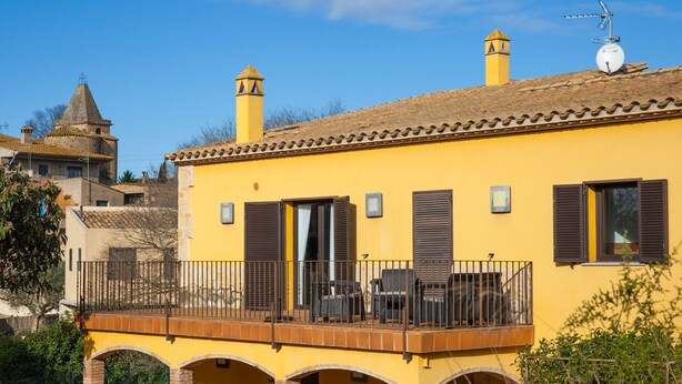A yellow building with a balcony, a chimney, and a satellite dish. - House with private pool, isolated and very quiet at the end of town. (Llampaies)