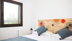 A bedroom with a bed, pillows, a nightstand, a lamp, and a window. - House with private pool, isolated and very quiet at the end of town. (Llampaies)