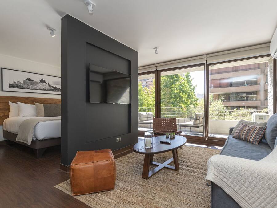 A modern living room with a sofa, a coffee table, and a TV mounted on the wall.