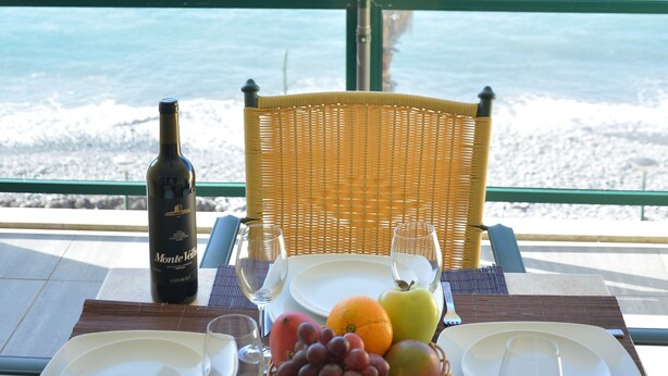 A table set for two with a bottle of wine, a basket of fruit, and a view of the ocean. - Atlantic view 1 - Apartment with ocean view & pool (Funchal)