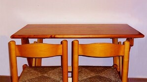 Una mesa de madera con dos sillas.