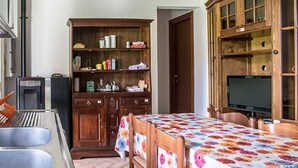 A kitchen with a refrigerator, a sink, and wooden cabinets.