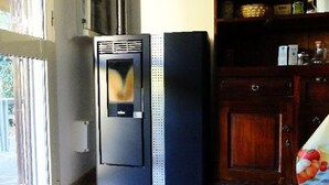 A kitchen with a refrigerator, a microwave, and a wooden cabinet.