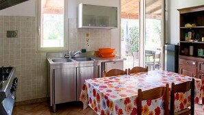 A kitchen with a dining table, a stove, and a sink.