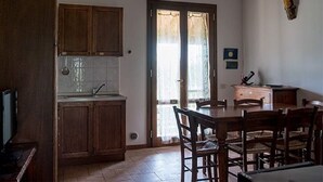 Eine Küche mit Holzausstattung, einem Spülbecken und einem Essbereich mit Tisch und Stühlen.