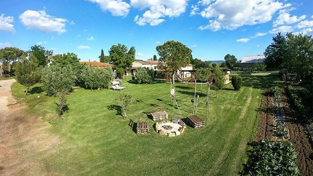 Ein Wohngebiet mit gepflegtem Rasen, einem kleinen Garten und einigen Gebäuden, darunter ein Pavillon und ein Schuppen.