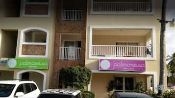 A building with two balconies, a spa-medication sign, and a hair salon sign.