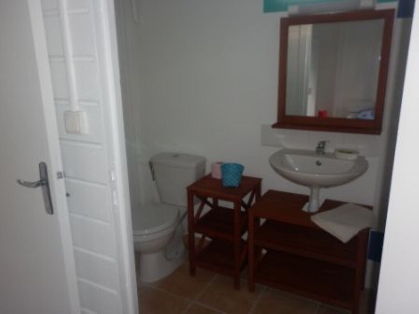 Une petite salle de bain avec des toilettes, un lavabo et un miroir.