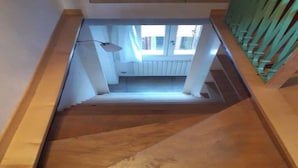 A wooden staircase with a view of a room with a window and a radiator. - Casa Sofia in the heart of Venice (Venezia)