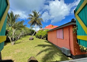 A small, colorful building with a red roof and a green door.
