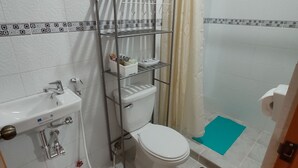 Une salle de bain comprenant des toilettes, un lavabo et un espace douche.