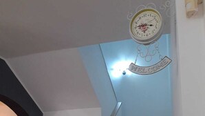 Un escalier avec un mur bleu clair et une horloge décorative sur laquelle est affiché le mot « BIENVENUE ».