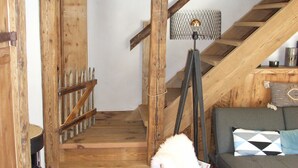 A wooden staircase leading to a loft area with a sofa and a lamp. - Chalet with view, in a quiet area, close to all services in summer and winter. (Saint-Gervais-les-Bains)
