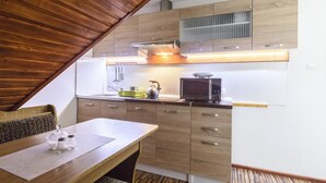 Una cocina moderna con armarios de madera, un microondas y una tetera sobre la encimera.