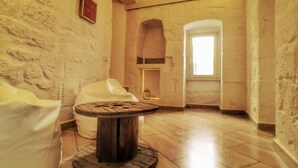 Una habitación con una mesa de madera rústica, un sofá blanco y una pared de piedra con un letrero que dice 'KEEP SIMPLE'.