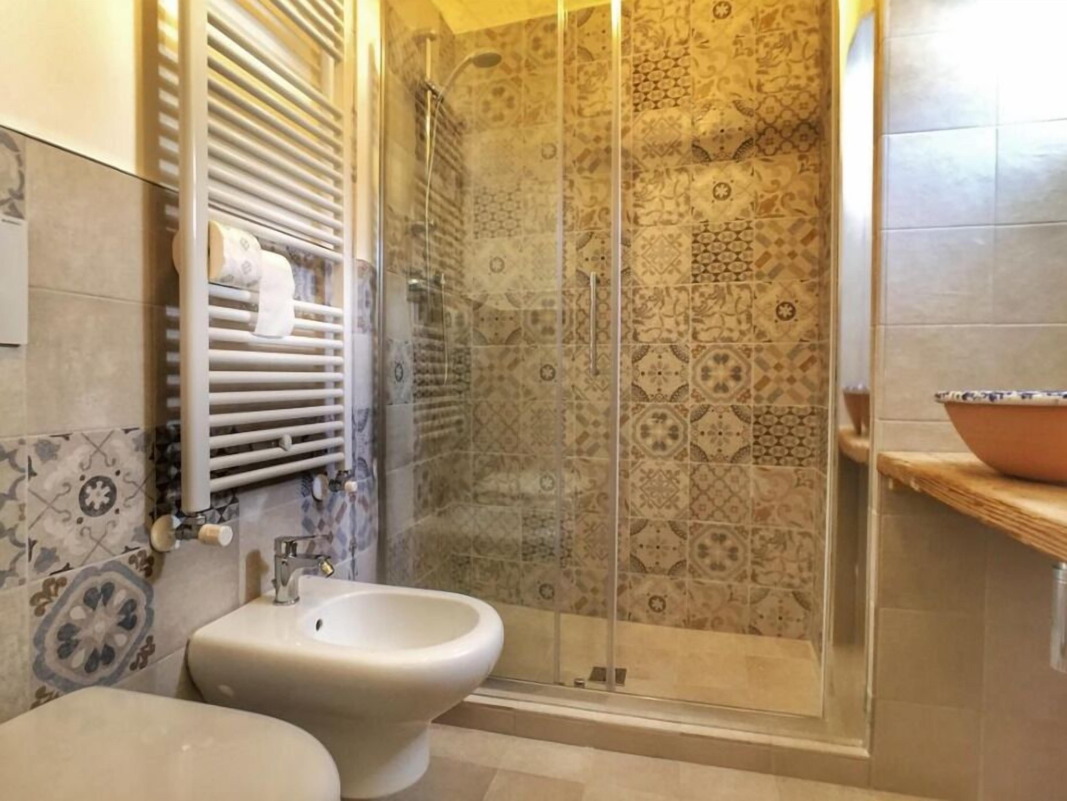 A bathroom with a shower enclosure, a bidet, and a toilet.