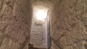 Una estrecha escalera de piedra con barandilla, que lleva a un acceso con un cartel que dice "hello".
