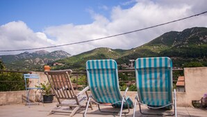 Two striped lounge chairs on a terrace with a mountain view. - Les deux chemins (Mons)