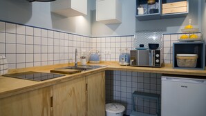 A modern kitchen with wooden cabinets, a built-in oven, a sink, and a coffee maker. - Il Grande Blu (Terracina)