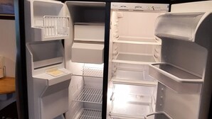 An open walk-in refrigerator with multiple shelves and a freezer compartment. - Antebellum home (Chauvin)