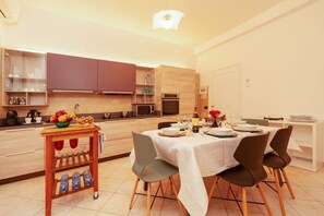 Eine moderne Küche mit Essbereich, ausgestattet mit einer Mikrowelle, einem Backofen und einem kleinen Kühlschrank.