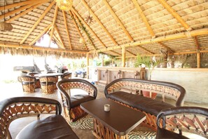 Relax in a shaded outdoor seating area with wicker chairs and tables, perfect for taking in the views.